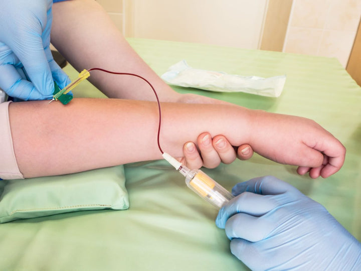 pediatric blood draw with dr wearing surgical gloves