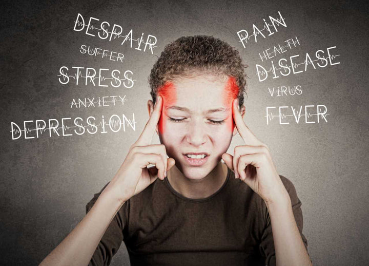 A stressed child with fingers on temple with closed eyes and different negative words surroung him