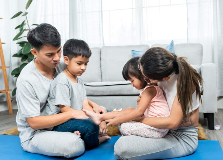 Parents seated with their children with each parent holding one child
